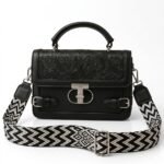 Black floral embossed faux leather satchel bag with silver clasp and black white chevron wide strap.