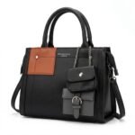 Close-up front angle of black and tan accent multi-pocket women handbag.