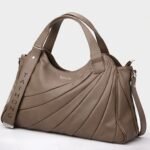Taihongyoupin branded women's large hobo tote bag in deep-khaki, featuring a unique fan-pleated design on the right panel and a prominent "TAIHONG" logo strap on the left. This stylish leather handbag includes dual top handles and a detachable shoulder strap against a plain white background.