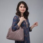 Taihongyoupin branded women's large hobo tote bag in taupe-brown, featuring a unique fan-pleated design on the right panel and a prominent "TAIHONG" logo strap on the left. This stylish leather handbag includes dual top handles and a detachable shoulder strap against a plain white background.
