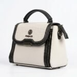 Three-quarter angled studio view of the FOXJAZZ off-white handbag showing side zipper detail and strap attachment ring.