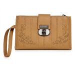 A tan faux leather women's long wallet, often called a wristlet clutch, crafted with smooth materials. The tan surface features vertical linear stitching and symmetrical corner embroidery of gold-colored floral roses and tendrils. The central point holds a prominent gunmetal twist-lock mechanism with a unique circular white insert. A wristlet strap is attached on the left side.