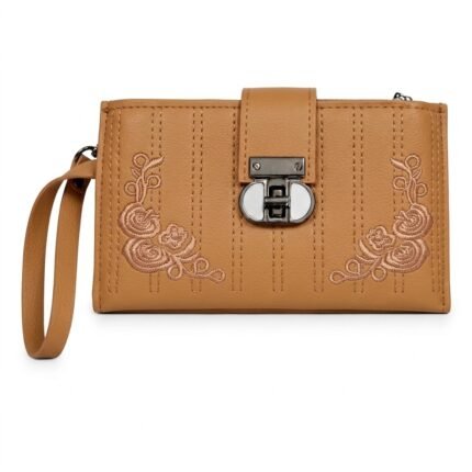 A light caramel-brown faux leather women's long wallet designed as an embroidered wristlet clutch, featuring a fine pebble-grain texture. Symmetrical floral rose embroidery in tan thread adorns the bottom corners, divided by parallel vertical stitching. A distinct central gunmetal turn-lock closure with a white insert and a tan wristlet strap complete the design.